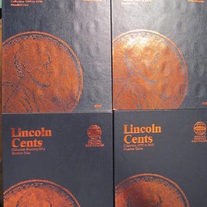 May include: Four dark blue coin folders with copper-colored text and imagery. The folders are labeled "Lincoln Cents" and feature a large penny design. The collections span from 1909 to 2019.