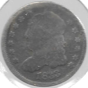May include: A close-up of an antique coin, likely a silver quarter, with a profile of a person on the obverse. The coin has a worn appearance, with visible stars and the year 1833. The coin is encased in a protective plastic sleeve.