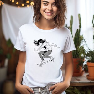 May include: White t-shirt with a black and white illustration of a person skateboarding. The person is wearing a hoodie and jeans.