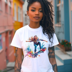 May include: A white t-shirt with a colorful graphic print of a woman skateboarding. The graphic features splashes of blue, green, yellow, orange, and pink paint.