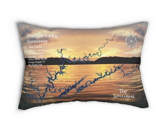May include: A decorative cushion featuring a sunset image of Norris Lake, Tennessee. The lake is outlined in blue and the text "Norris Lake Tennessee" and "Lake Facts" are printed on the cushion. The cushion also includes the text "THE WILLIAMS".
