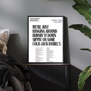Op de afbeelding: Een zwart-witte printbare poster met de tekst van het nummer "Burnin' It Down" van Jason Aldean. De tekst bevat de zinnen "Old Boots, New Dirt" en "We're just hanging around burnin' it down sippin' on some cold Jack Daniel's".