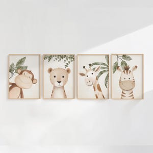 May include: Set of four framed art prints featuring watercolor illustrations of jungle animals. The prints include a monkey, a lion, a giraffe, and a zebra, each with a friendly expression and set against a neutral background.