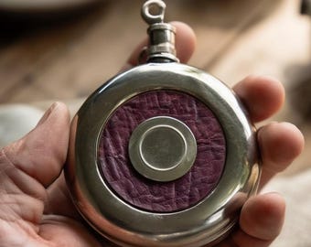 Fiaschetta tascabile rotonda vintage con inserto in pelle. Borraccia in metallo in stile antico.