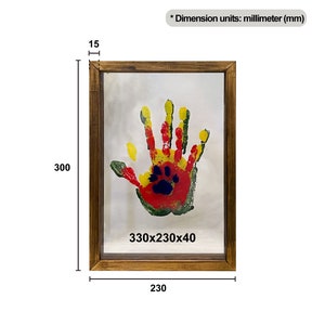 May include: A framed handprint art piece. The wooden frame surrounds a handprint in red, yellow, green, and blue. The frame measures 9.05 x 13 x 0.6 inches, with a depth of 0.6 inches. The handprint is on a white background.