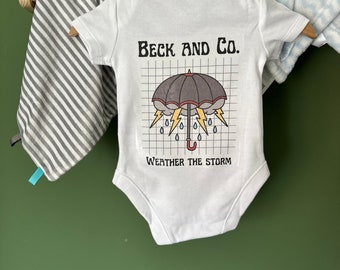 Ropa infantil única Beck and Co. Storm Baby Design disponible como mono o camiseta para bebé, colores personalizables, desde recién nacido hasta los 5 años