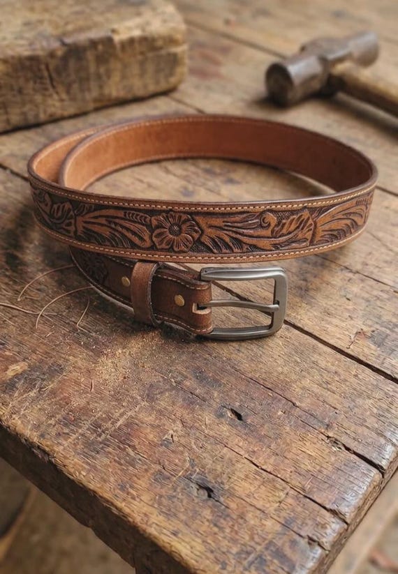 Fully hand-tooled floral Western leather belt — the kind of cowboy craft skill that takes real hours and looks stunning.