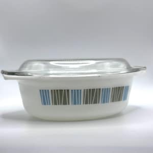 May include: White casserole dish with a clear glass lid. The dish has a pattern of vertical blue and grey stripes. The dish has two small handles. A vintage kitchenware item.