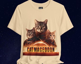 Może przedstawiać: Beżowa koszulka z grafiką przedstawiającą trzy koty, zachód słońca i napis "CAT MAGEDDON". Koty mają szczegółowe wzory futra i są umieszczone na ciemnym, gwiaździstym tle.