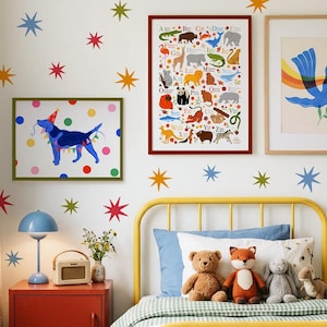 Könnte beinhalten: Ein Kinderzimmer mit gelbem Bettrahmen, rotem Nachttisch und gerahmten Kunstwerken. Die Wand ist mit bunten Sternaufklebern verziert. Das Bett hat ein blaues Kissen, einen Teddybären, einen Fuchs-Plüsch und ein graues Stofftier. Kunstwerke umfassen eine Tier-Alphabet-Tabelle.