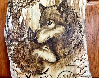 May include: A woodburned image of two wolves with a full moon in the background. The wolves are in a forest setting with trees and clouds. The image is done in shades of brown and black.