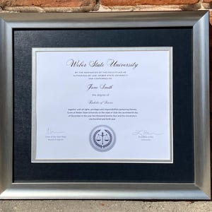 May include: A framed diploma from Weber State University, awarded to Jane Smith for the degree of Bachelor of Science. The diploma is dated December 17, 2024.