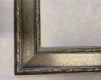 May include: A rectangular picture frame featuring a metallic bronze finish with a distinct crackled texture. The frame is adorned with ornate, raised scrollwork patterns along the inner and outer edges, creating a decorative border.