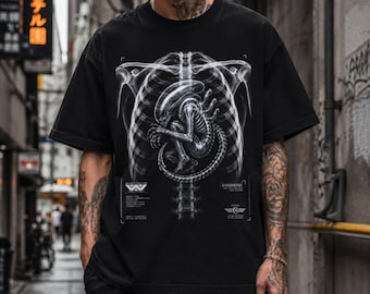 May include: Black t-shirt featuring a detailed, white skeletal graphic of an alien embryo within a rib cage. The design includes technical details and the stylized letters "W". A unique, science fiction-themed apparel item.