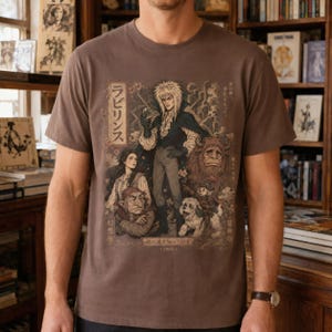 A woman wears a black t-shirt with a graphic of Jareth the Goblin King, Sarah, Hoggle, Ludo, and Sir Didymus in a Japanese poster art style, with Japanese text on the left.