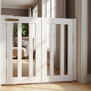May include: White wooden baby gate with vertical slats and a brass latch. The gate is installed in a doorway, with a glimpse of a living room visible through the slats. The gate is designed to keep children or pets safe.