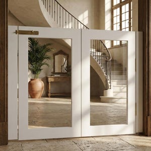 Può includere: Porte doppie bianche con pannelli di vetro e un chiavistello in ottone. Le porte riflettono una scala con ringhiera curva e una grande pianta in vaso. L'interno ha una palette di colori neutri.