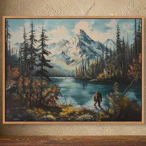 May include: A framed painting depicting a serene mountain lake scene with a lone figure standing in the water. The painting features a blue sky, snow-capped mountains, lush green trees, and a calm lake. The figure is wearing a brown jacket and pants and appears to be looking out at the lake.