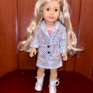 May include: A doll with long blonde hair wearing a silver sequined dress and white boots.