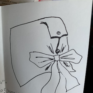May include: A black and white line drawing of a bonnet with a large bow. The drawing is on a white background with text that reads "of bonnet section. 1/2" again. Top-"