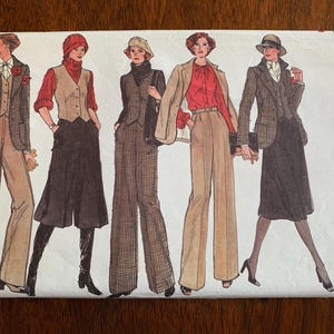 Puede incluir: Un sobre de patrón de costura Vogue Patterns para la talla S, con ilustraciones de cinco conjuntos que incluyen blazers, chalecos, pantalones anchos y faldas en tonos marrón, beige, rojo y negro, con el texto Vogue Patterns.