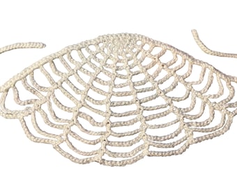 Könnte beinhalten: Cremefarbene, handgestrickte Gesichtsbedeckung mit Spinnennetz-Design. Die Maske hat zwei Schlaufen für die Ohren und ist aus dickem, strukturiertem Garn gefertigt. Ein einzigartiges, handgefertigtes Accessoire.