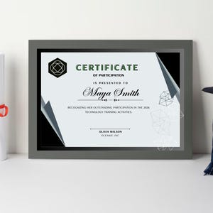 Puede incluir: Un certificado enmarcado gris con un diseño geométrico en blanco y negro. El certificado dice "CERTIFICATE OF PARTICIPATION IS PRESENTED TO Maya Smith RECOGNIZING HER OUTSTANDING PARTICIPATION IN THE 2004 TECHNOLOGY TRAINING ACTIVITIES OLIVIA WILSON OCEANIC INC"
