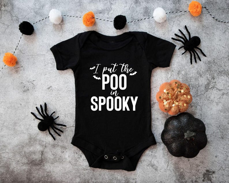 K&ouml;nnte beinhalten: Ein schwarzer, kurz&auml;rmeliger Babybody mit dem wei&szlig;en Schriftzug I put the POO in SPOOKY und kleinen Fledermausgrafiken. Das Kleidungsst&uuml;ck hat einen Rundhalsausschnitt und drei Druckkn&ouml;pfe aus Metall im Schrittbereich zum Verschlie&szlig;en.