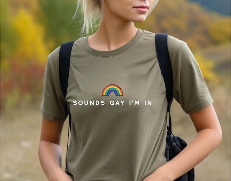 May include: A green t-shirt with a rainbow and the text 'Sounds Gay I'm In' printed on the front.
