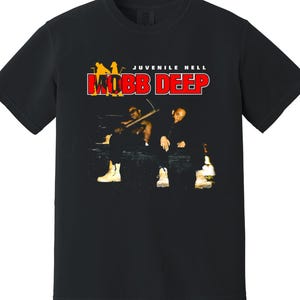 May include: Black t-shirt with the red text "MOBB DEEP" and a graphic of two people. The words "JUVENILE HELL" are above the main text. The graphic shows two people sitting with a piano and bottles.