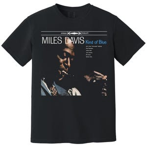 May include: Black t-shirt featuring a portrait of Miles Davis with the text "MILES DAVIS Kind of Blue" in white and blue. The image shows Davis with a musical instrument. The shirt is a classic crew neck.