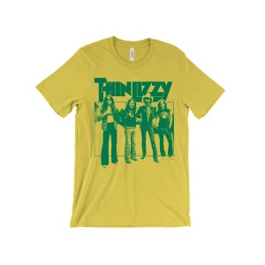 May include: A yellow t-shirt with a green print of the band Thin Lizzy. The print features a photo of the band members in a group pose.