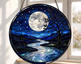 May include: Round stained glass panel depicting a moonlit night scene. A large, segmented moon dominates the sky, with a river winding through a landscape of dark blue hills and a silhouetted tree. The panel is framed in black and hangs from a chain.