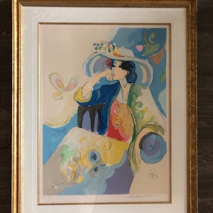 Könnte beinhalten: Ein gerahmter, farbenfroher Druck einer Frau, die einen großen weißen Hut mit Blumen trägt. Sie sitzt auf einem Stuhl vor einem blauen und violetten Hintergrund. Der Druck ist mit "Michel Soyer" signiert.