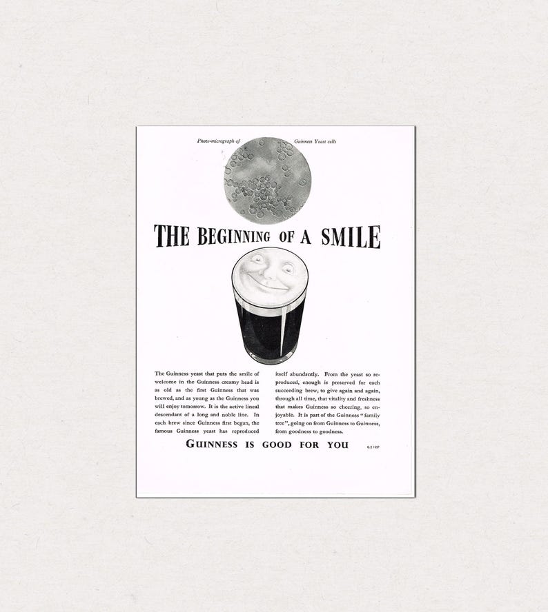 Puede incluir: Anuncio publicitario vintage de Guinness stout. El anuncio en blanco y negro presenta una pinta de Guinness sonriente, una imagen microsc&oacute;pica de c&eacute;lulas de levadura y el texto "THE BEGINNING OF A SMILE" y "GUINNESS IS GOOD FOR YOU".
