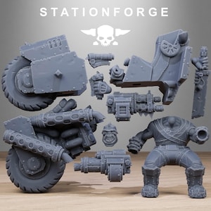 May include: Gray plastic model kit of a futuristic vehicle and a figure, with the text "STATIONFORGE" and a skull logo. The kit includes various components like wheels, weapons, and body parts, suggesting a miniature war game theme.