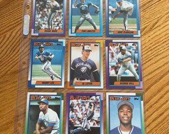 May include: Nine baseball trading cards featuring Toronto Blue Jays players. The cards are arranged in three rows of three. Each card features a player in a Blue Jays uniform, with their name and team printed below.