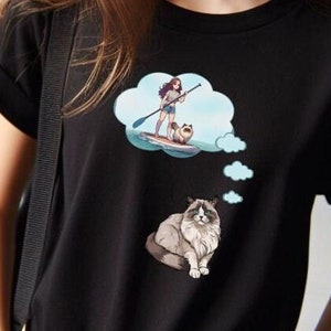 This short sleeve T-Shirt features a Ragdoll Cat with a thought bubble and inside the big thought bubble is an anime style girl on a paddleboard with the cat on front. The large design is centered on the front of the T-Shirt.