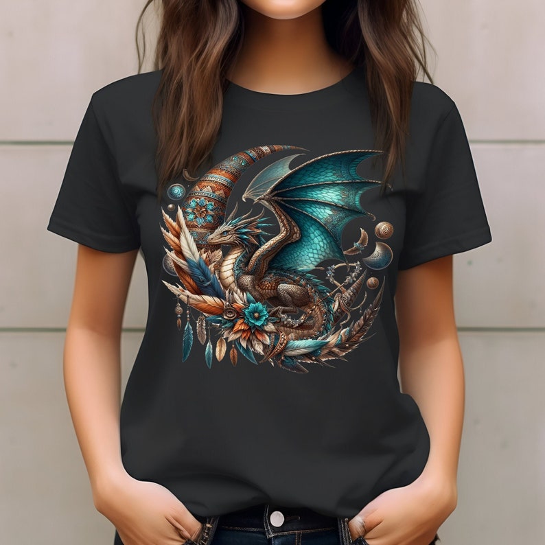 This short-sleeved t-shirt features a vivid dark boho mystical dragon in turquoise and brown hues, on a crescent moon adorned with feathers, pocket watches and planets. The large design is centered on the front of the t-shirt.
