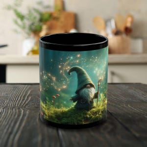 May include: Black ceramic mug with a magical forest scene featuring a gnome holding a staff. The gnome is wearing a blue pointed hat and has a white beard. The background is a dark blue with stars and sparkles.