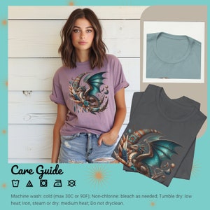 May include: Purple t-shirt with a graphic of a teal dragon curled around a crescent moon. The dragon has gold accents and is surrounded by feathers and beads. The t-shirt has a crew neck and short sleeves. Care instructions are included: Machine wash cold, tumble dry low, do not dry clean.