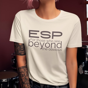 May include: A white t-shirt with a gray graphic that reads "ESP For those who see beyond the obvious".
