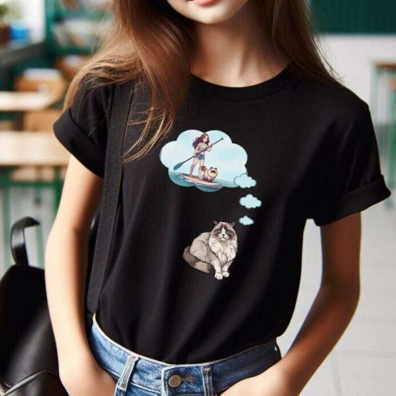 This short sleeve T-Shirt features a Ragdoll Cat with a thought bubble and inside the big thought bubble is an anime style girl on a paddleboard with the cat on front. The large design is centered on the front of the T-Shirt.