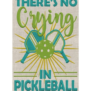 May include: Embroidered wall art with the text "THERE'S NO CRYING IN PICKLEBALL". The design features a green pickleball, two teal paddles, and yellow sunburst rays on a beige background.