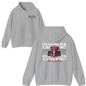 May include: A gray hooded sweatshirt with a checkered flag graphic on the front and a Formula One race car graphic with the text "CHARLES LECLERC Formula One" on the back.