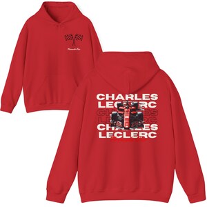 May include: Red hooded sweatshirt with a Formula One race car graphic and the text "Charles Leclerc" repeated multiple times on the back.