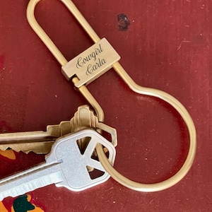 May include: Gold key chain with a loop and a small engraved tag that reads "Cowgirl Carla".