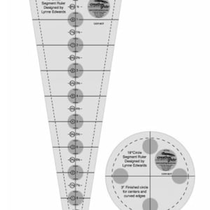 May include: A white 18-inch circle segment ruler with markings for creating circles and curved edges. The ruler is designed by Lynne Edwards and is part of the Creative Grids line of quilting tools.
