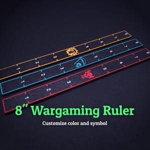 Puede incluir: Tres reglas de wargaming de 8 pulgadas con una superficie negra texturizada y bordes de colores naranja, azul y rojo. Cada regla presenta marcas numeradas del 1 al 8 y un símbolo gráfico único, incluyendo una calavera sol, una parca y una calavera con cuernos.