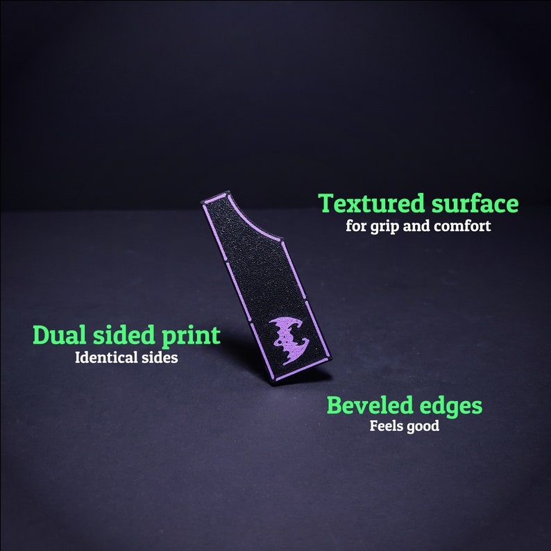 May include: Black, textured grip with a purple bat design. Features dual-sided printing and beveled edges. The text on the image says "Textured surface for grip and comfort", "Dual sided print Identical sides", and "Beveled edges Feels good".